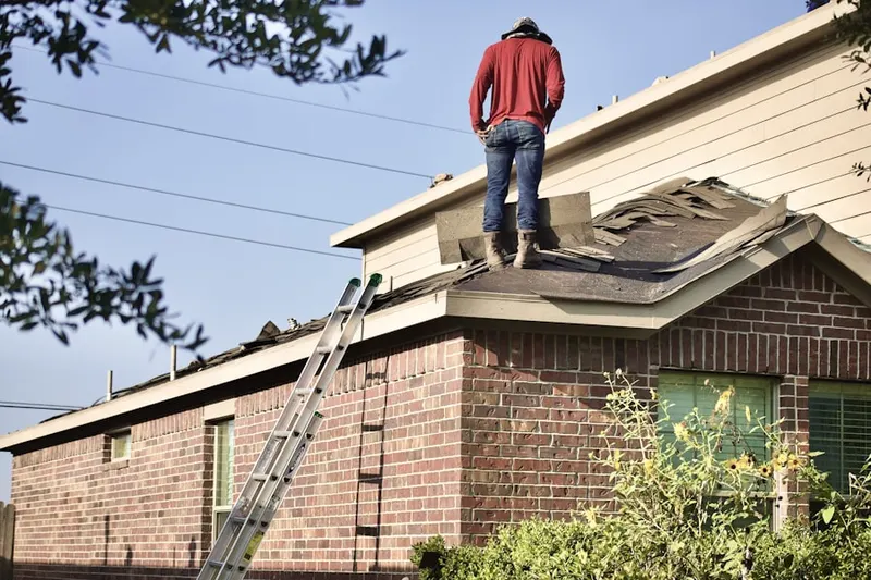 Professional roofer working on a residential roof in Howell